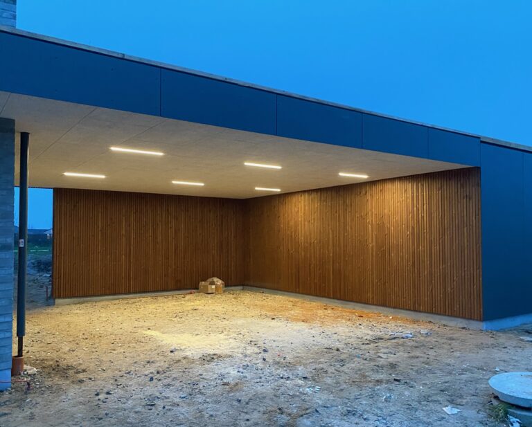 Tilbygning af garage i træ stil, udvidet til mere plads og lækkert lys design.